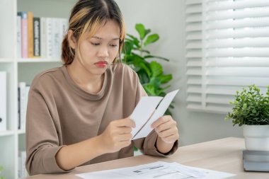 Yüklü faturaları ve faturaları olan stresli ve baş ağrısı çeken Asyalı kadın harcamaları ve kredi kartı borçlarını ödeyecek parası yok. kıtlık, mali sorunlar, mortgage, kredi, iflas, iflas, yoksul, boş cüzdan