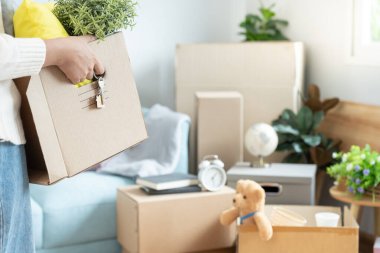 Taşınmak, taşınmak. Karton kutuda yeni apartman malzemeleri vardı. Odanın içinde kişisel eşyalar ve mobilyalar olan bir karton kutu vardı. Dairelere girin.