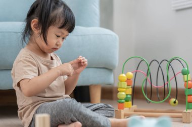 Mutlu Asyalı çocuk oyun oynuyor ve oyuncak bloklarını öğreniyor. Çocuklar evde çok mutlu ve heyecanlı. Çocuk oyun oynarken, etkinliklerde, gelişimde, dikkat eksikliğinde hiperaktivite bozukluğunda harika zaman geçirir.