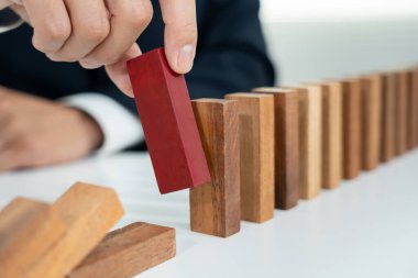 Domino 'yu elleri olan sigorta korur. İş adamı elleri iş krizinde domino taşlarının düşmesini durdurur. işletme risk denetimi ve planlama ve işletmeler sigorta işletmelerini önlemek için stratejiler.