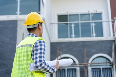 Müfettiş ya da mühendis mavi baskı kullanarak inşaat ve kalite güvencesini denetliyor. Mühendis, mimar ya da irtibat kurucu ev sahibine teslim etmeden önce evi inşa etmek için çalışıyor.