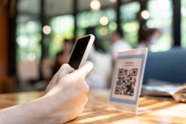 Woman use smartphone to scan QR code to pay in cafe restaurant with a digital payment without cash. Choose menu and order accumulate discount. E wallet, technology, pay online, credit card, bank app.