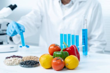 Bilimadamı laboratuardaki kimyasal meyve artıklarını kontrol ediyor. Kontrol uzmanları kimyasal kalıntıların konsantrasyonunu inceliyor. Tehlike, standart, yasaklı maddeleri bul, kirlet, mikrobiyolog