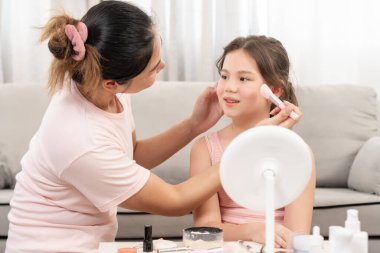 Anne mutlu çocuklar için makyaj yapıyor ve öğretmenlik yapıyor. Makyaj yapan kız. Aktivite ailesi, reklam, yaşam tarzı, kozmetik, makyaj malzemeleri, güzellik etkinliği, güzellik uzmanı, yetenek, aşk güzelliği.