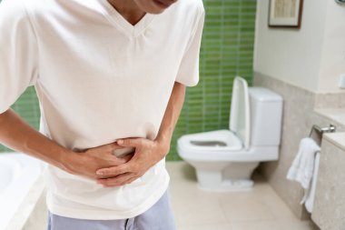 Kabızlık ve ishal banyoda. Yaralı adam karnına dokunuyor. Karın ağrısı. kolon iltihabı sorunu, zehirli besin, karın ağrısı, karın ağrısı, tuvalette kabızlık, mide ağrısı, hijyen...