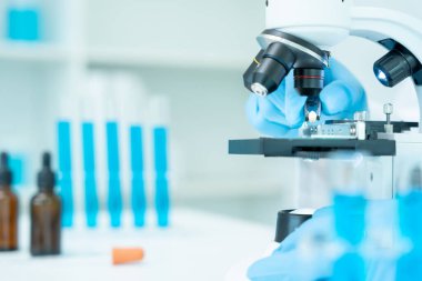 Gelişmiş bilim laboratuarındaki biyokimyasal örnekleri analiz et. Tıbbi profesyonel kullanım mikroskobu virüsün mikrobiyolojik gelişimini gösteriyor. Fen laboratuvarında biyoteknoloji araştırması.