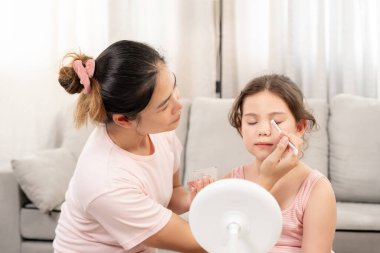 Anne mutlu çocuklar için makyaj yapıyor ve öğretmenlik yapıyor. Makyaj yapan kız. Aktivite ailesi, Reklam, yaşam tarzı, kozmetik, makyaj malzemeleri, güzellik etkinliği, güzellik uzmanı, yetenek, aşk güzeli.