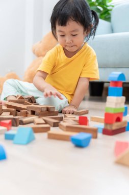 Mutlu Asyalı çocuk oyun oynuyor ve oyuncak bloklarını öğreniyor. Çocuklar evde çok mutlu ve heyecanlı. Çocuk oyun, etkinlik, gelişme ve dikkat eksikliği hiperaktivite bozukluğuyla çok iyi vakit geçiriyor