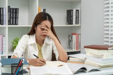 Asian student woman have anxiety because of exams, female prepare for test and learning lessons in the library. stress, despair, haste, misunderstanding reading, discouraged, expectation, knowledge