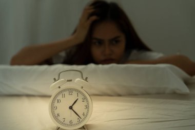 Asyalı kadın geç saatlere kadar uyumaya çalışıyor uykusuzluk çekiyor, uykusuzluk çekiyor ya da bir kabusta korkuyor üzgün endişeli ve stresli görünüyor. Yorgun ve baş ağrısı ya da gecenin bir yarısı uyanan migren..