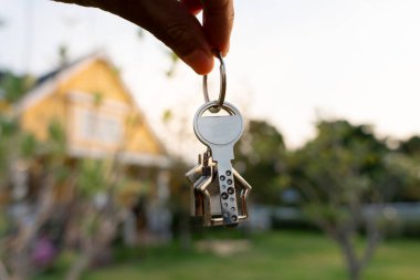 Kira, kiralama ve ev satma. Emlakçının elinde yeni sahibinin anahtarı var. kira, satış, kredi finans, sigorta, satıcı, dağıtıcı, taksit, satın alma, satma, taşınma