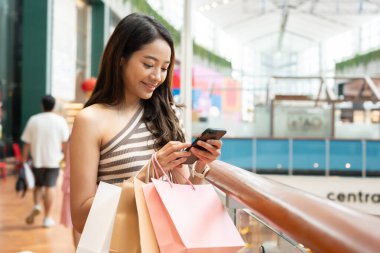 Modern mutlu Asyalı kadın moda portresi. Güzel, çekici bir genç kız sokakta alışveriş torbalarıyla şık yürüyüşler yapıyor, alışveriş merkezlerinde moda kıyafetler, internet ürünleri...