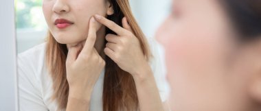 Genç Asyalı kadın, yüz dermatolojisi ve kozmetik ürünlerinde steroidlere alerjisi olduğu için endişeli. Hassas cilt, güneş yanığı, sivilce, kimyasallara alerjisi, yüzünde kızarıklık. cilt sorunları ve güzellik