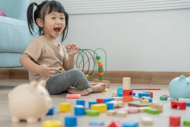 Mutlu Asyalı çocuk oyun oynuyor ve oyuncak bloklarını öğreniyor. Çocuklar evde çok mutlu ve heyecanlı. Çocuk oyun, etkinlik, gelişme ve dikkat eksikliği hiperaktivite bozukluğuyla çok iyi vakit geçiriyor