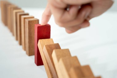 Domino 'yu elleri olan sigorta korur. İş adamı elleri iş krizinde domino taşlarının düşmesini durdurur. işletme risk denetimi ve planlama ve işletmeler sigorta işletmelerini önlemek için stratejiler.
