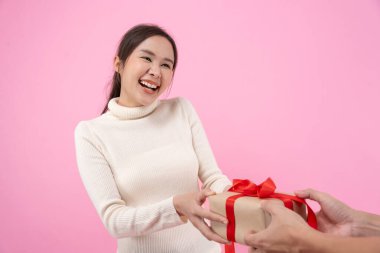 Güzel Asyalı kadın şaşırdı ve ilgi çekici hediye kutusuna baktı. Sevimli kız hediye kutusunu açtı. Doğum günü, kutlama, xmas, yeni yıl festivali, teşekkür, kutlama, sevgililer günü, yıldönümü