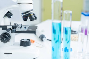 Bilimadamı ileri bilimsel laboratuvarda biyokimyasal örnekleri analiz ediyor. Tıbbi profesyonel kullanım mikroskobu virüsün mikrobiyolojik gelişimini gösteriyor. Fen laboratuvarında biyoteknoloji araştırması.