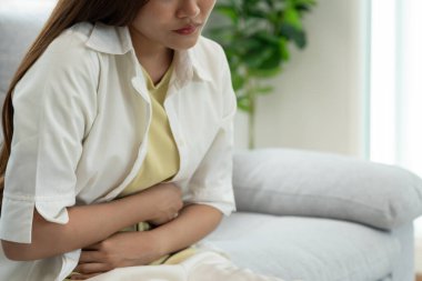 stomach ache. Asian women have abdominal pain, indigestion, gastritis, menstrual cramps, flatulence, diarrhea, distention, colon cancer, belly inflammation problem, suffer food poisoning, abdomen