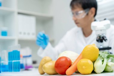 Scientist check chemical food residues in laboratory. Control experts inspect quality of fruits, vegetables. lab, hazards, ROHs, find prohibited substances, contaminate, Microscope, Microbiologist