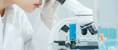 Bilimadamı ileri bilimsel laboratuvarda biyokimyasal örnekleri analiz ediyor. Tıbbi profesyonel kullanım mikroskobu virüsün mikrobiyolojik gelişimini gösteriyor. Fen laboratuvarında biyoteknoloji araştırması.