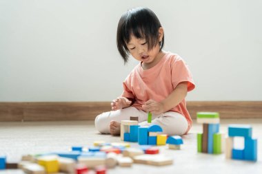 Mutlu Asya çocukları oyuncak bloklarıyla oynayıp öğreniyor. Aile evde mutlu ve heyecanlı. Kızın zaman, etkinlik, gelişme, IQ, EQ, meditasyon, beyin, kaslar, temel beceriler.