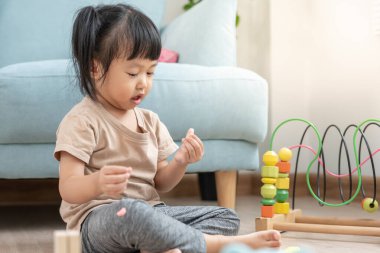 Mutlu Asya çocukları oyuncak bloklarıyla oynayıp öğreniyor. Aile evde mutlu ve heyecanlı. Kızın zaman, etkinlik, gelişme, IQ, EQ, meditasyon, beyin, kaslar, temel beceriler.