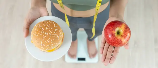 slim body Women refuse fast food or junk food, female choose apple for diet. Good healthy food. weight lose, balance, control, reduce fat, low calories, routines, exercise. rejection symbol