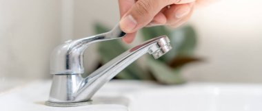Save water. Volunteer keeps turning off the running water in the bathroom to protect environment. Greening planet, reduce global warming, Save world, life, future, risk energy, crisis , water day.