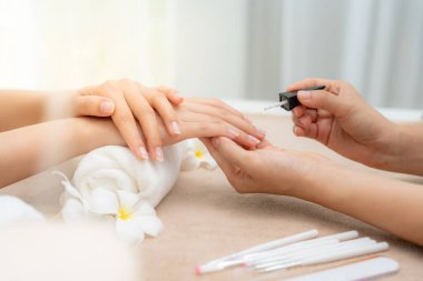 Kadın, güzellik merkezinde profesyonel güzellik manikürü ile bakım hizmeti alıyor. Güzellik salonunda jöle tedavisi için tırnak törpüsü kullanın. Manikürcü, çivi müşterisini güzelleştirir. vücut bakımı spa tedavisi