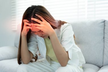 Ağrı ve migren yüzünden çaresiz ve stresli baş ağrısı çekiyor. Çalışırken migren ağrısı çeken Asyalı genç adam, mavi izole edilmiş arka plan, beyin tümörü, yüksek kolesterol etkisi