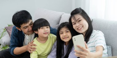 Taşınmak, taşınmak. Aile gülümsemesi ve yeni eve taşındıktan sonra fotoğraf çektirmek. Odanın içinde kişisel eşyalar ve mobilyalar bulunan bir karton kutu vardı. Yeni daireye taşın, apartman dairesi.