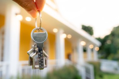 Kira, kiralama ve ev satma. Emlakçının elinde yeni bir ev ya da emlak için anahtar var. kira, satış, kredi finans, sigorta, satıcı, dağıtıcı, taksit, satın alma, satma, taşınma