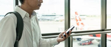 İş adamı, internet başvurusu üzerinden uçak bileti almak için cep telefonu kullanıyor, seyahat saatlerini kontrol ediyor, seyahat, seyahat, ödeme, vade, rezervasyon, online, kontrol ediyor.