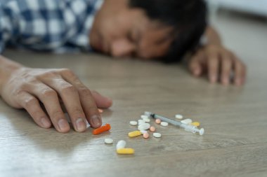 Asyalı erkek aşırı dozda hap kullanıyor, stresli, üzgün, uyuşturucu bağımlısı, uyuşturucu bağımlısı, hasta, sağlıksız, mutsuz, intihar, depresyonda veya umutsuz, uyuşturucu bağımlısı, yaşam ve aile sorunları, motivasyonsuz