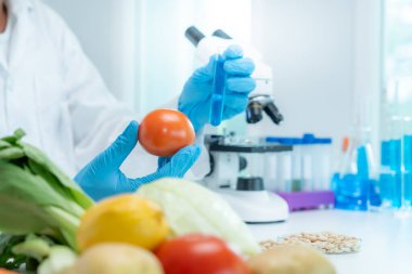 Scientist check chemical food residues in laboratory. Control experts inspect quality of fruits, vegetables. lab, hazards, ROHs, find prohibited substances, contaminate, Microscope, Microbiologist