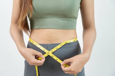 Diyet ve diyet. Güzel, ince kadın vücut ölçüsü. Spor elbiseli bir kadın sağlıklı yaşam için kilo verme hedefine, zayıflığa, ince belliye, beslenme uzmanına ulaşır.