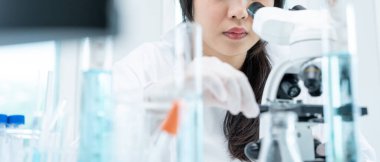 Bilimadamı ileri bilimsel laboratuvarda biyokimyasal örnekleri analiz ediyor. Tıbbi profesyonel kullanım mikroskobu virüsün mikrobiyolojik gelişimini gösteriyor. Fen laboratuvarında biyoteknoloji araştırması.