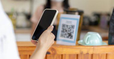 Woman use smartphone to scan QR code for order menu in cafe restaurant with a digital delivery. Choose menu and order accumulate discount. E wallet, technology, pay online, credit card, bank app.