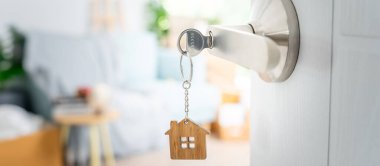 Moving house, relocation. The key was inserted into the door of the new house, inside the room was a cardboard box containing personal belongings and furniture. move in the apartment or condominiu