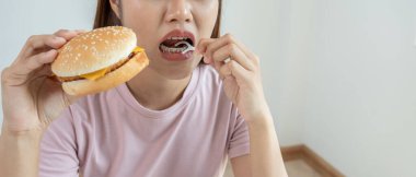 Diş bakımı tedavisi. Kadın diş telleri yemek parçacıklarını temizlemek için diş ipi kullanır. Dişlerin üzerindeki metal bileklikler. Genç, diş tellerinden sonra özen gösteren, ortodontiye güvenen. Ağız kokusunun ve diş çürüğünün giderilmesi.