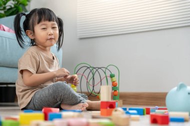 Mutlu Asyalı çocuk oyun oynuyor ve oyuncak bloklarını öğreniyor. Çocuklar evde çok mutlu ve heyecanlı. Çocuk oyun, etkinlik, gelişme ve dikkat eksikliği hiperaktivite bozukluğuyla çok iyi vakit geçiriyor