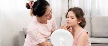 Anne mutlu çocuklar için makyaj yapıyor ve öğretmenlik yapıyor. Makyaj yapan kız. Aktivite ailesi, reklam, yaşam tarzı, kozmetik, makyaj malzemeleri, güzellik etkinliği, güzellik uzmanı, yetenek, aşk güzelliği.