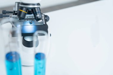 Bilimadamı ileri bilimsel laboratuvarda biyokimyasal örnekleri analiz ediyor. Tıbbi profesyonel kullanım mikroskobu virüsün mikrobiyolojik gelişimini gösteriyor. Fen laboratuvarında biyoteknoloji araştırması.
