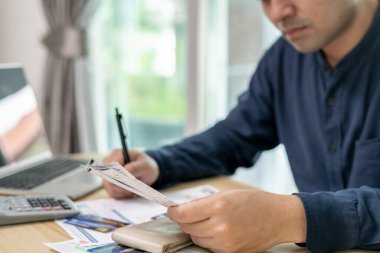 Yüklü faturaları ve faturaları olan stresli ve baş ağrısı çeken Asyalı bir adamın harcamaları ve kredi kartı borçlarını ödeyecek parası yok. kıtlık, mali sorunlar, mortgage, kredi, iflas, iflas, yoksul, boş cüzdan