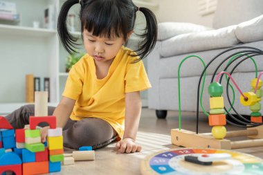 Mutlu Asyalı çocuk oyun oynuyor ve oyuncak bloklarını öğreniyor. Çocuklar evde çok mutlu ve heyecanlı. Çocuk oyun, etkinlik, gelişme ve dikkat eksikliği hiperaktivite bozukluğuyla çok iyi vakit geçiriyor