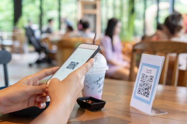 Kadın, kafeterya restoranında sipariş menüsü için dijital dağıtım ile QR kodunu taramak için akıllı telefon kullanıyor. Menüyü ve siparişi seçin ve indirimi toplayın. E cüzdan, teknoloji, online ödeme, kredi kartı, banka uygulaması