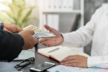 Businessmen receive salary or bonuses from management or Boss. Company give rewards to encourage work. Smiling businessman enjoying a reward at the desk in the office.