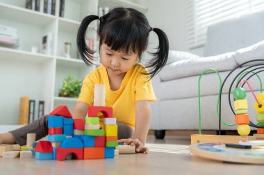 Mutlu Asya çocukları oyuncak bloklarıyla oynayıp öğreniyor. Aile evde mutlu ve heyecanlı. Kızın zaman, etkinlik, gelişme, IQ, EQ, meditasyon, beyin, kaslar, temel beceriler