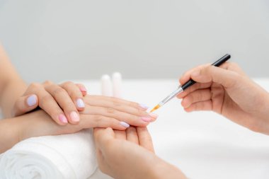 Kadın, güzellik merkezinde profesyonel güzellik manikürü ile bakım hizmeti alıyor. Güzellik salonunda jöle tedavisi için tırnak törpüsü kullanın. Manikürcü, çivi müşterisini güzelleştirir. vücut bakımı spa tedavisi