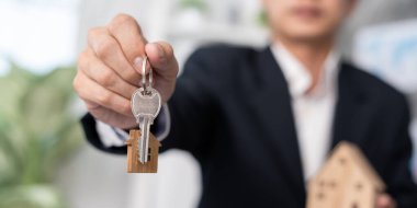 Kira, kiralama ve ev satma. Emlakçının elinde yeni bir ev ya da emlak için anahtar var. kira, satış, kredi finans, sigorta, satıcı, dağıtıcı, taksit, satın alma, satma, taşınma